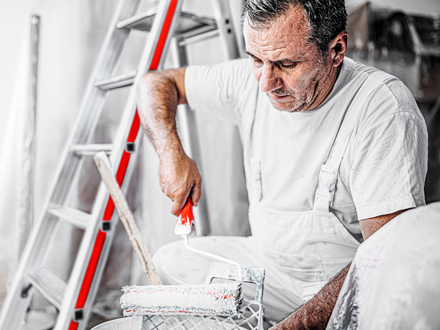 Maler vor Stufenstehleiter mit Plattform hat Steigtechnik-Wissen. 